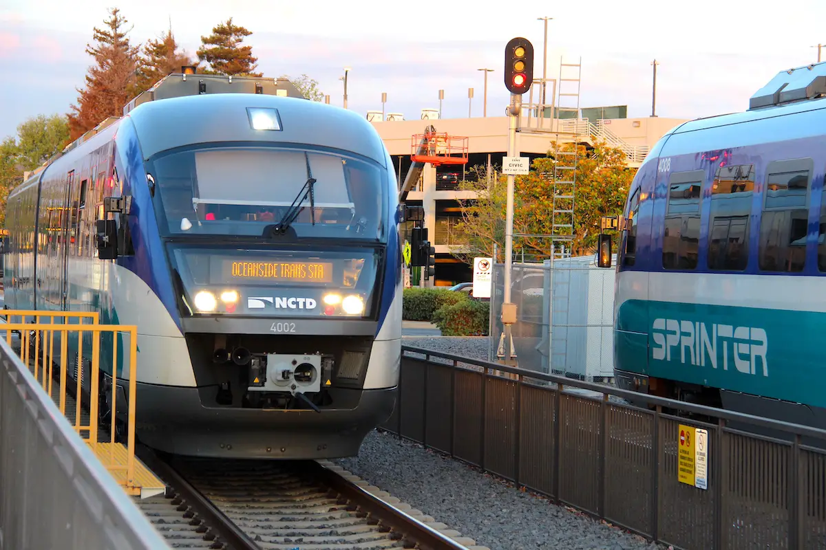 Two Sprinter trains pass each other at a station.
