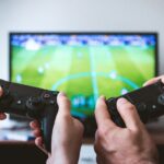 Player using a mobile device to enjoy classic games adapted for modern platforms