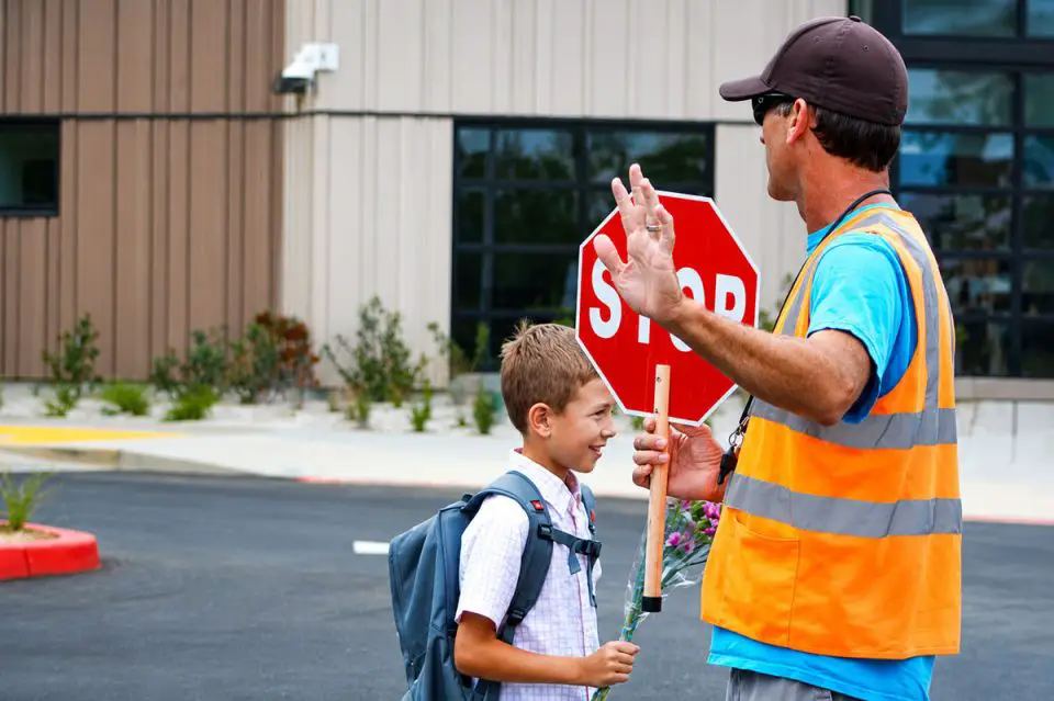 A crossing guard assists students near Del Mar Heights Elementary School. Encinitas leaders recently approved funding for crossing guards at local middle and high schools. File photo/Leo Place