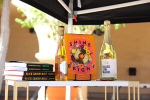A bottle of wine displayed next to books by Black authors.