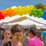 Attendees gather at a community festival during Oceanside Pride weekend in North County San Diego.