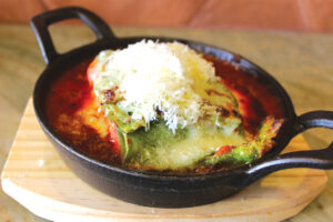 Layered spinach lasagna with ricotta, mozzarella and aged 24-month Parmigiano Reggiano cheeses in a pomodoro sauce. Guests can opt for Bolognese sauce as well. Photo by Rico Cassoni