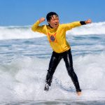 A student at Surfin Fire Oceanside celebrates catching a wave. Courtesy photo/Surfin Fire