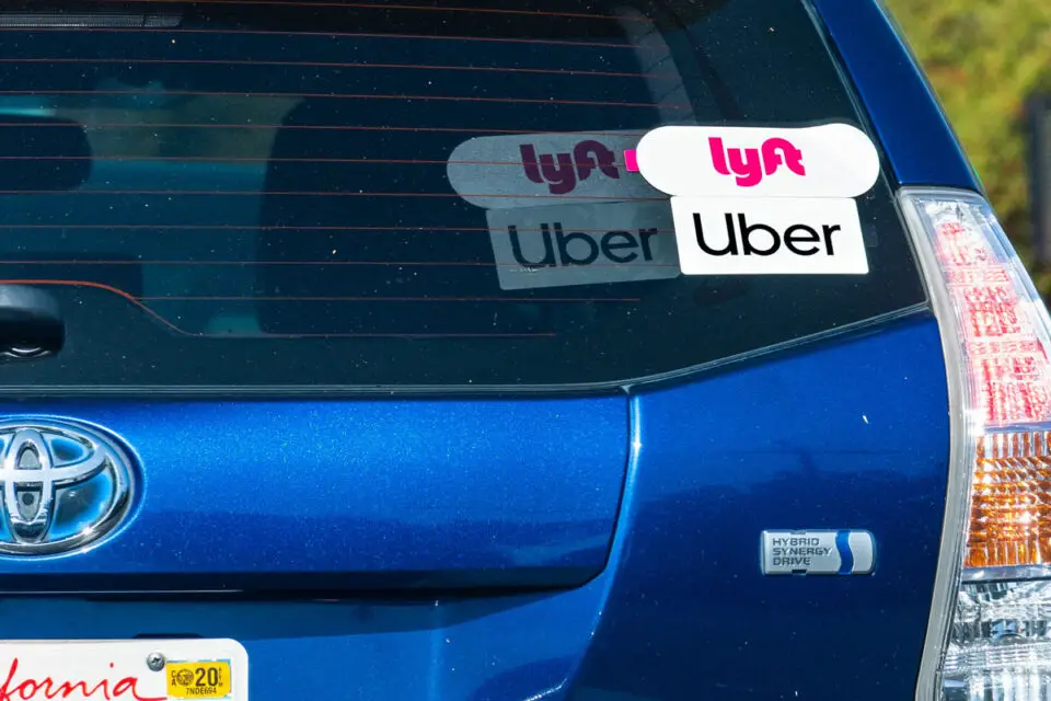 A vehicle displays rideshare decals for Uber and Lyft. A statewide ballot measure would expand rideshare company liability and impose new safety requirements. Photo by Sundry Photography