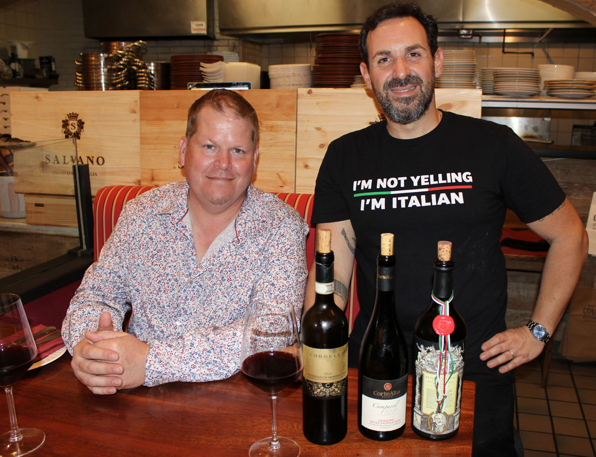 The Coast News Publisher Chris Kydd (left) and Colosseo Cucina Italiana Chef/Owner Roberto Ciacciofera showcasing The Imperor Pour lineup, with pours of Barolo, Amarone, and Brunello di Montalcino. Photo by Rico Cassoni