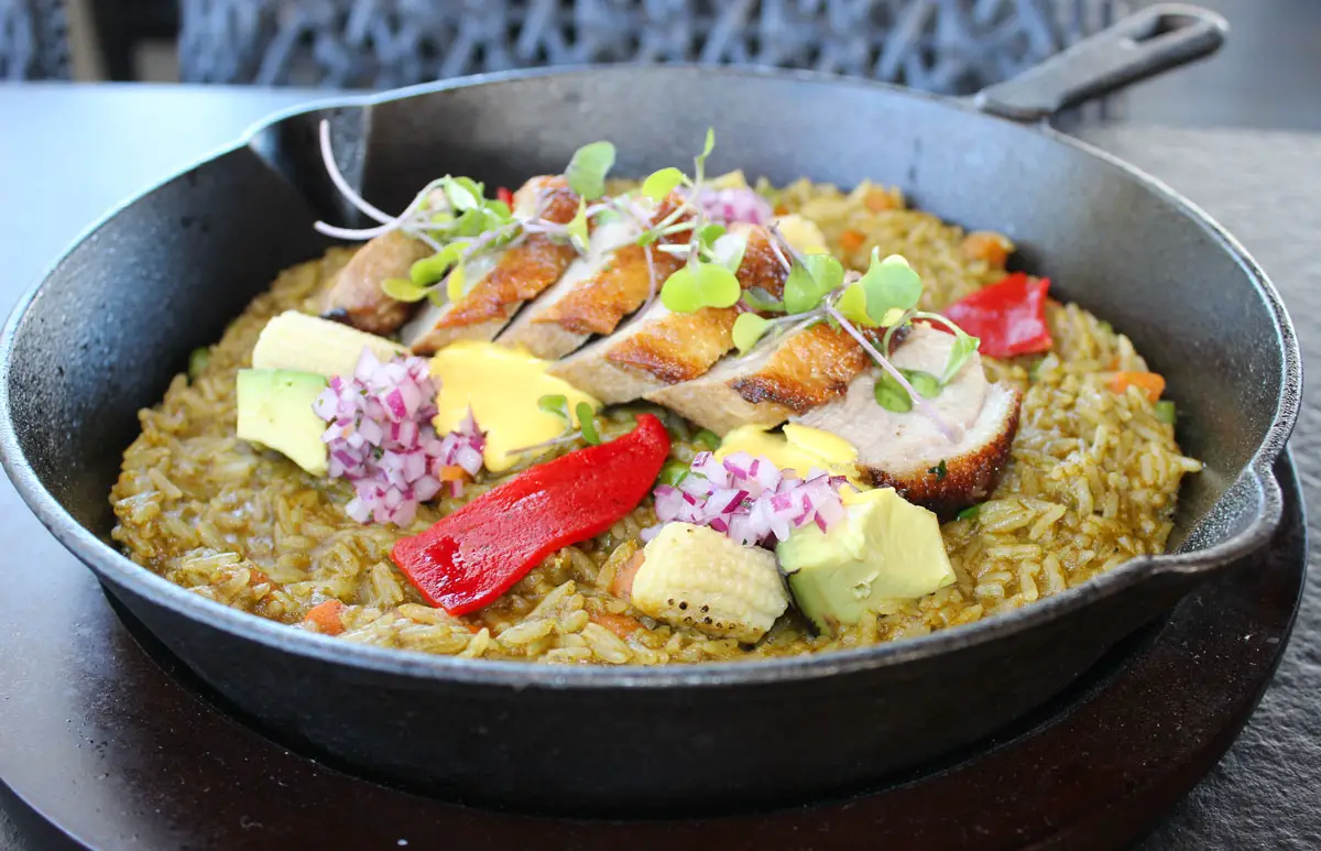 Duck breast served over traditional norteño rice with vegetables and Huancaina sauce. Photo by Rico Cassoni