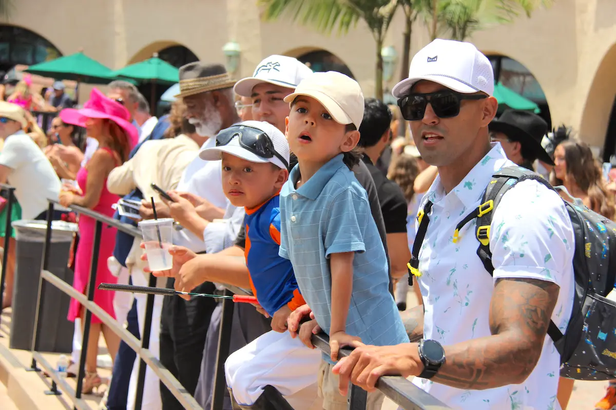 (From left) Abraham, four-year-old Aiden, and six-year-old Emilio look at the horses ahead of the first post on Opening Day of the Del Mar summer racing season on July 17. Photo by Leo Place