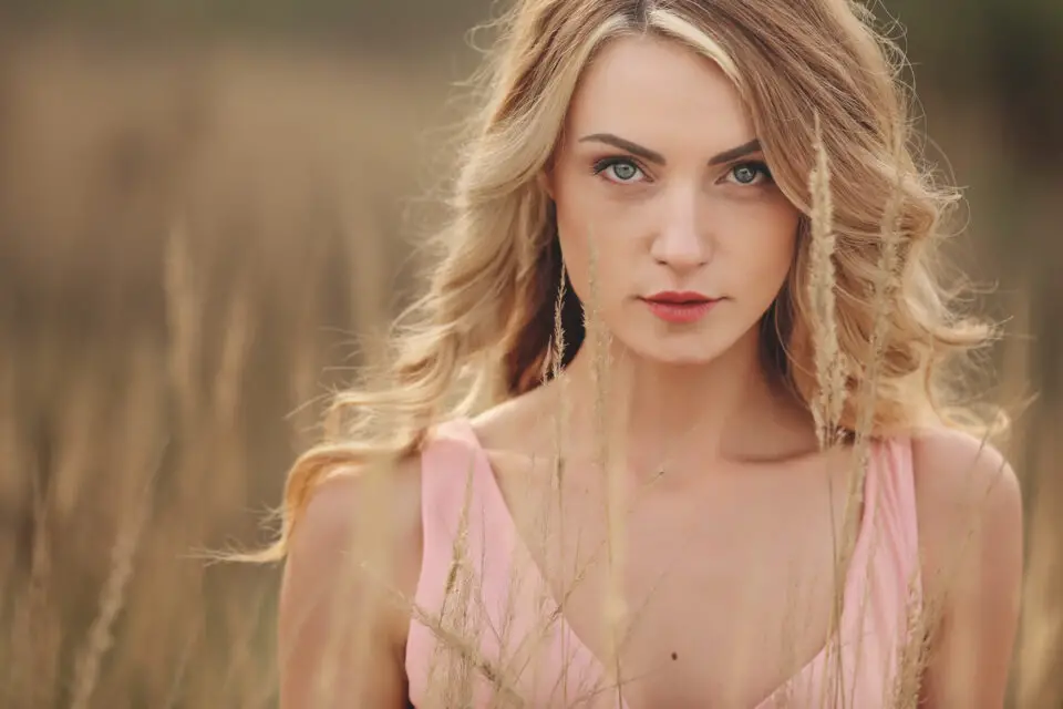 Blonde woman with healthy, shiny hair illustrating proper hair care and hydration techniques.
