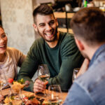 Friends enjoying food and drinks together at a casual dining cafe.