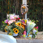 Flowers and family photos mark a roadside memorial for 17-year-old Seraphina Rose Fadick on El Camino Del Norte in Encinitas. Photo by Leo Place