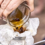 A homemade herbal tincture is filtered through cheesecloth after a four- to six-week steeping process, separating the liquid extract from the calendula flowers before it is blended into a body cream. Courtesy photo
