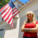 San Marcos resident Amy Cooke received a $100 fine from her HOA for flying her American flag outside her garage, which the HOA says violates regulations. Photo by Leo Place