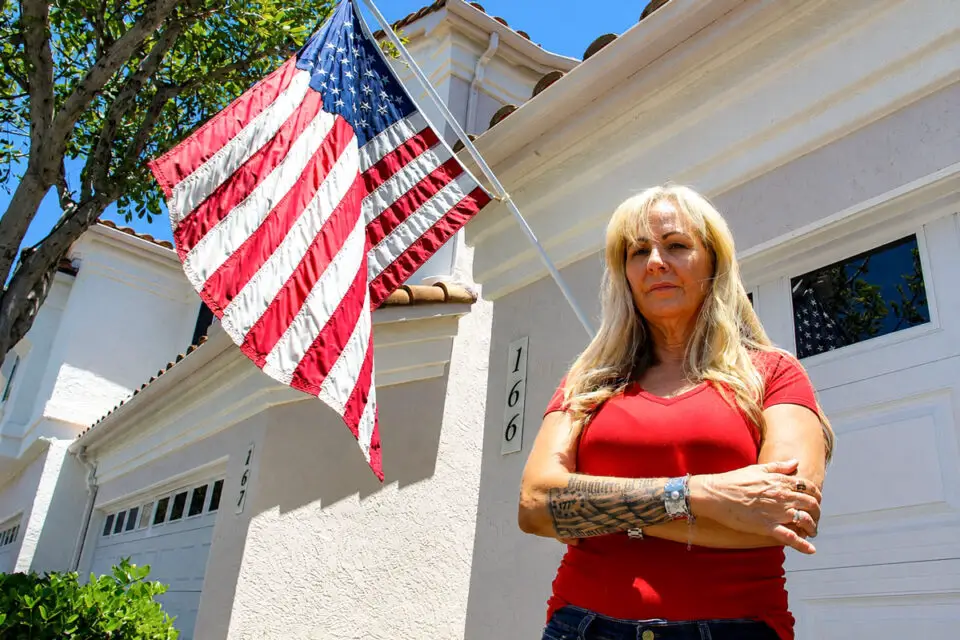 San Marcos resident Amy Cooke received a $100 fine from her HOA for flying her American flag outside her garage, which the HOA says violates regulations. Photo by Leo Place