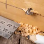 Measuring woodwork accurately before installing replacement cabinet handles.