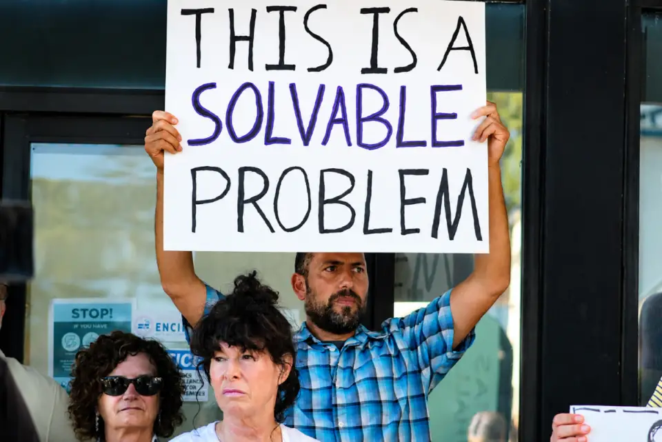 Residents hold signs calling for safer streets during a July 21 rally outside Encinitas City Hall. Safe Streets Encinitas organized the event to urge city leaders to improve traffic and pedestrian safety. Photo by Samantha Nelson