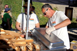 A man grills hot dogs