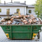 Residential skip bin filled with renovation debris outside a home.