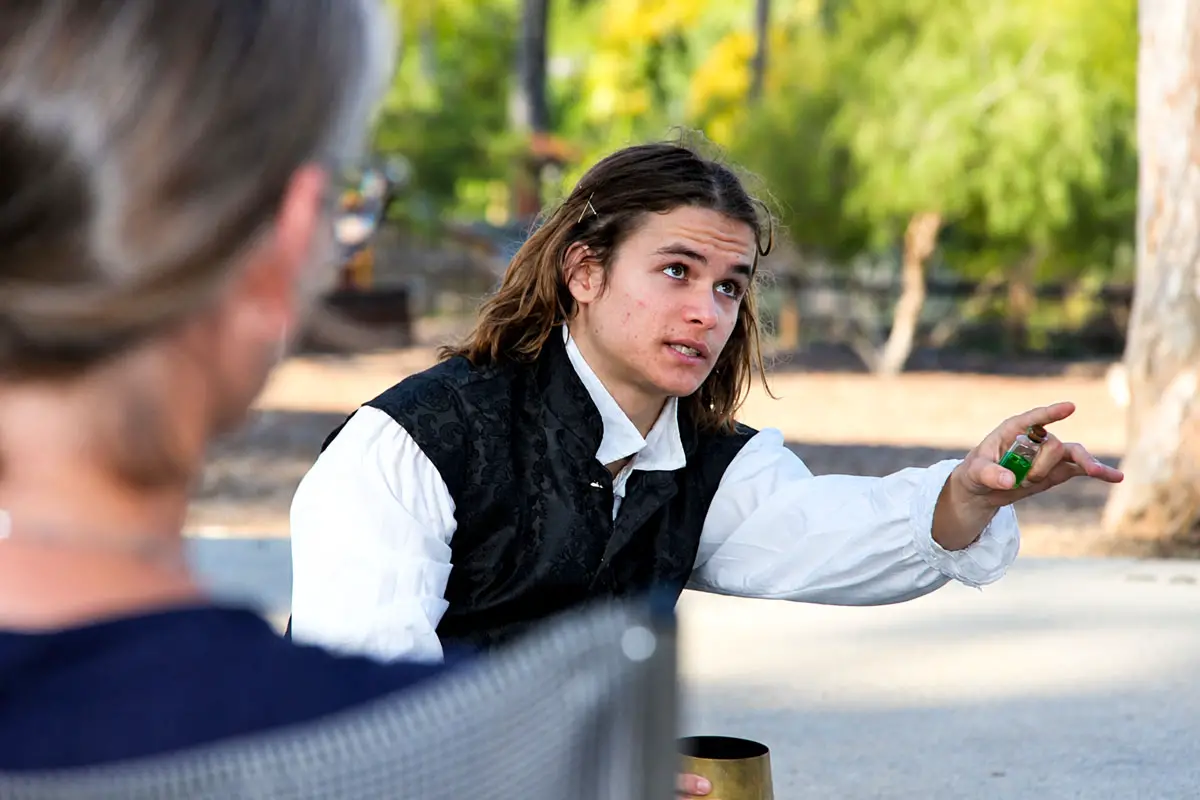Gabriel Bergseid, playing Camillo, holds a bottle of poison given to him by King Leontes during a performance of “The Winter’s Tale” at the Olivenhain Meeting Hall on July 16. Photo by Leo Place