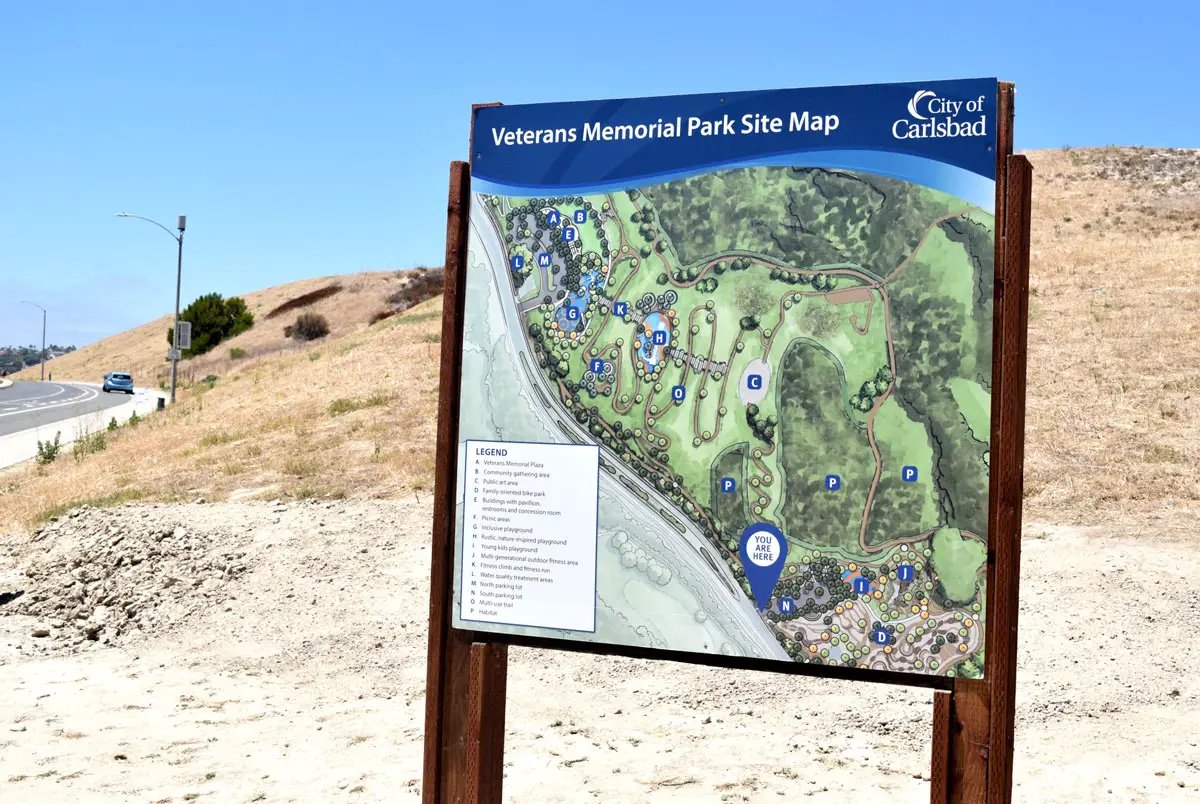 A sign displaying a rendering of the future Veterans Memorial Park stands at the project site in Carlsbad on July 6 during the park's groundbreaking ceremony. Construction of the city's largest park is expected to take 22 to 24 months. Photo by Summer Hu