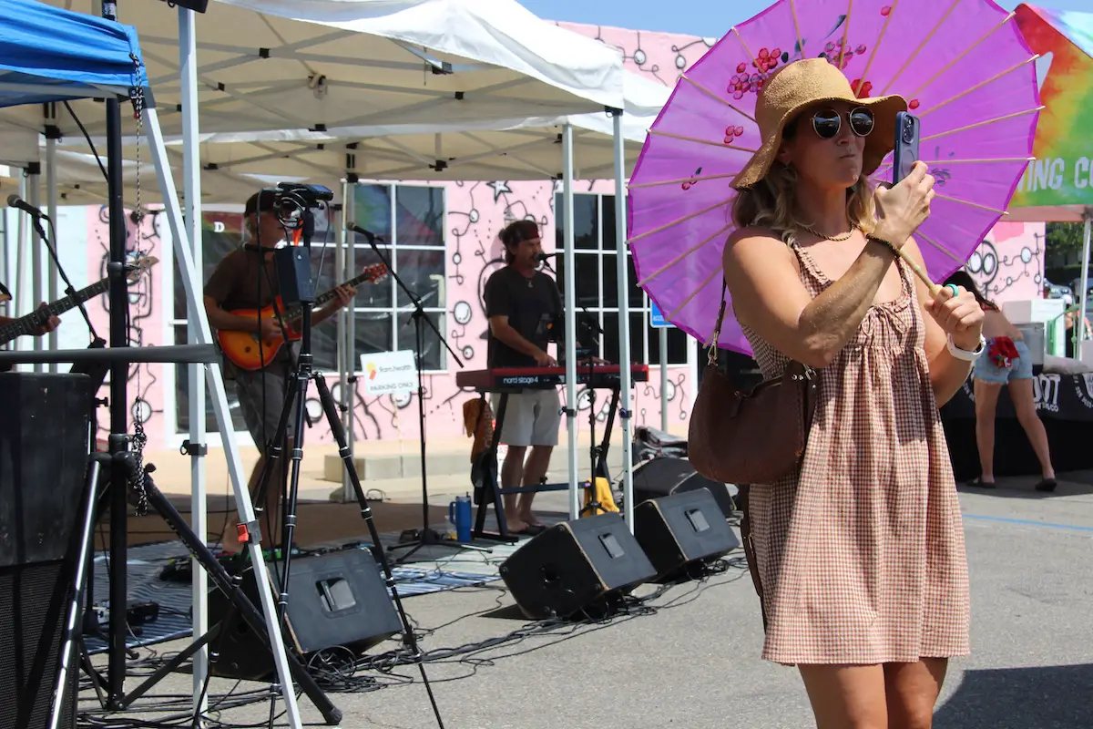 A woman takes a selfie as a band plays at LeucadiART Walk. Photo by Cameron Adams