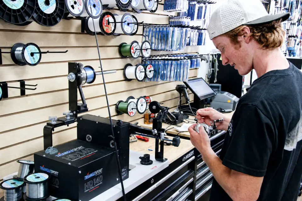Merrick Meyers spools a fishing reel at North County Bait & Tackle, his family’s new shop in Encinitas. Photo by Cameron Adams