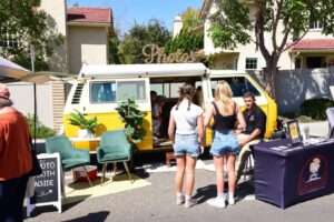 Attendees stop to engage with a business exhibitor at the Encinitas Oktoberfest & Artisan Faire
