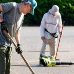 Fallbrook residents Franz Pusch and Mike Crowell fill potholes along Sumac Road early one Saturday morning this summer. Photo by Samantha Nelson