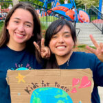 Kids for Peace interns hold signs during a recent Back 2 School Bash at Poinsettia Park in Carlsbad. Courtesy photo/Kids for Peace
