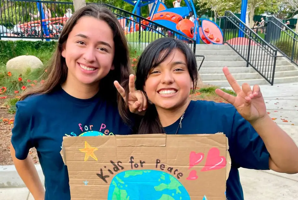 Kids for Peace interns hold signs during a recent Back 2 School Bash at Poinsettia Park in Carlsbad. Courtesy photo/Kids for Peace