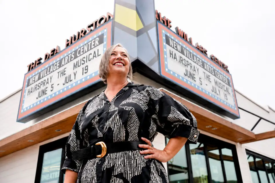 New Village Arts founder and Executive Artistic Director Kristianne Kurner stands in front of the Dea Hurston New Village Arts Center marquee in Carlsbad Village. Courtesy photo/NVA