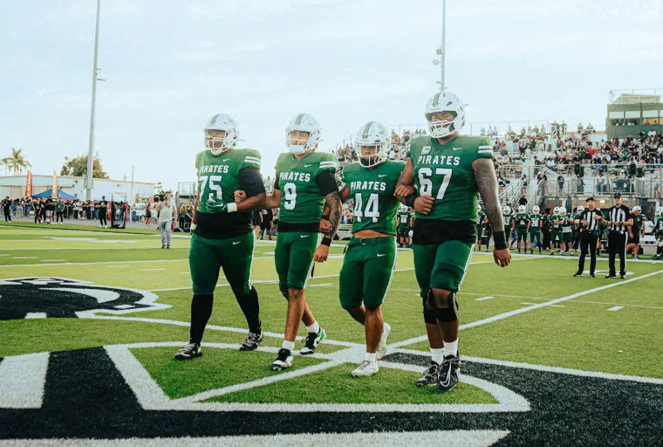 Oceanside football players gather at midfield before their season opener Aug. 21 against Granite Hills. Photo by Isaac Angel