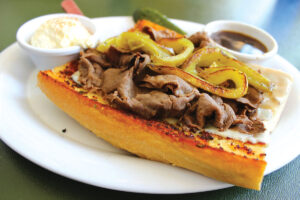 Hot Italian roast beef on grilled bread with melted cheese and peppers, accompanied by au jus. Photo by Rico Cassoni