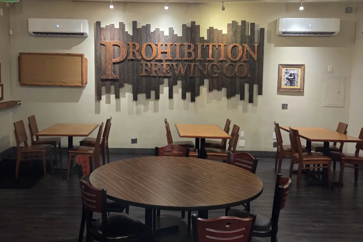 A carved wooden sign hangs on a wall inside the main dining room at Prohibition Brewing Co. Photo by Jim Trageser