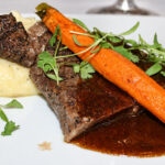 Grilled dry-aged ribeye, roasted carrot, and mascarpone-whipped potatoes paired with Groth 2022 Reserve Cabernet Sauvignon, the evening’s star pairing. Photo by Rico Cassoni