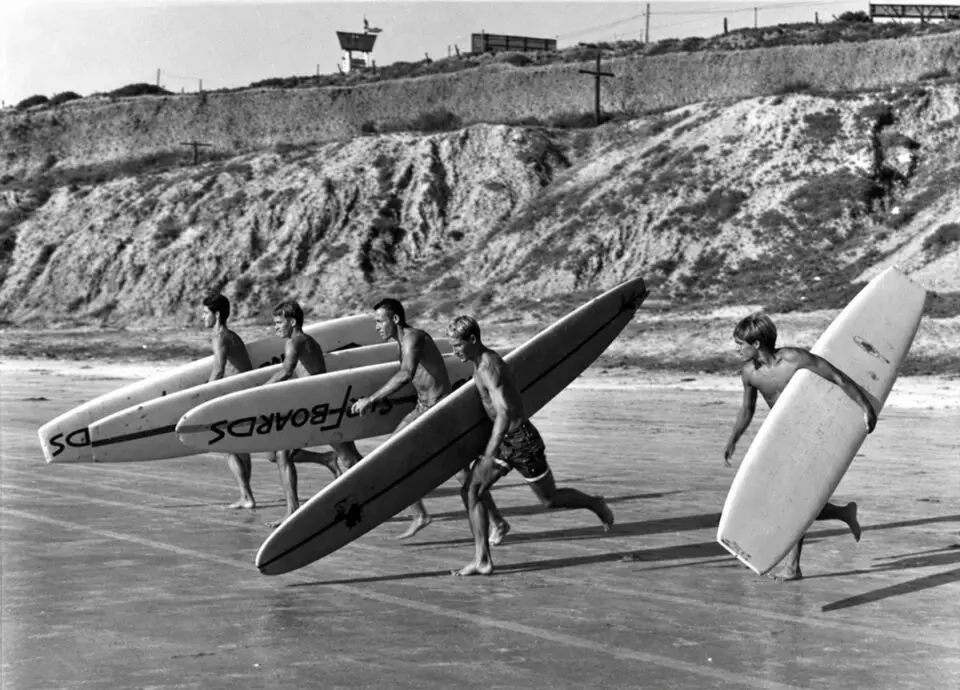 Surfers carry their boards toward the water during a 1965 paddle race in Del Mar. The city’s surfing heritage will take center stage at the inaugural Surf Del Mar Festival. Courtesy photo/Del Mar Historical Society