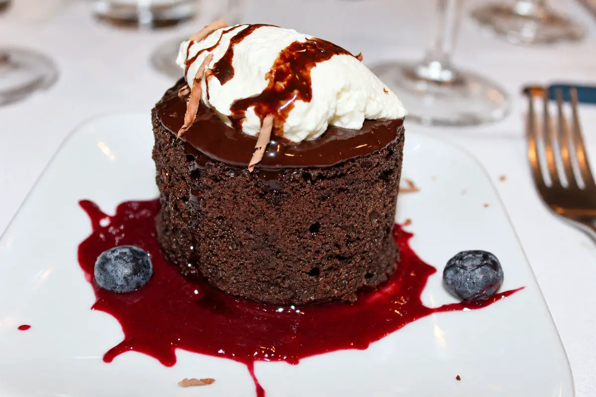 Dark chocolate lava cake with blackberry reduction and orange blossom whipped cream dry-aged ribeye, roasted carrot, and mascarpone-whipped potatoes paired with Groth 2021 Oakcross Proprietary Red. Photo by Rico Cassoni