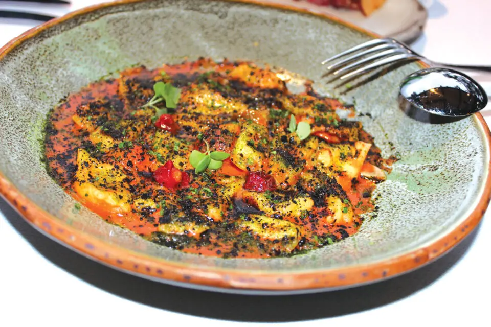 House-made agnolotti in a triple-cream sauce, accompanied by heirloom tomatoes, Urfa chili sauce and basil. Photo by Rico Cassoni