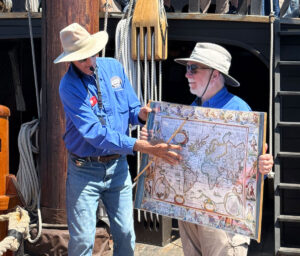 Maritime Museum volunteers Ken Golden, left, and Herb Bellucci give a history lesson on world trade routes and explorations of the 15th and 16th centuries for the 40 passengers aboard the San Salvador. The Maritime Museum is rated the third largest in the world because of its collection of vessels and hands-on experiences. Photo by Laurie Brindle