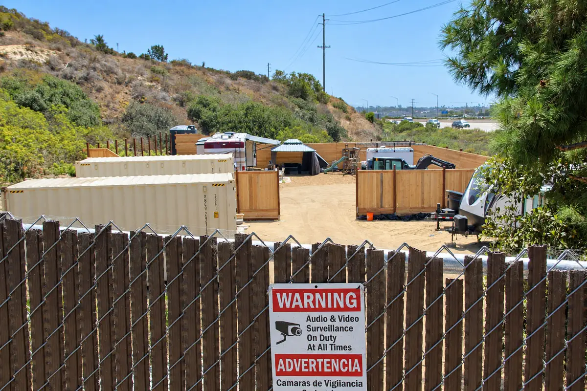 A surveillance warning sign hangs on a fence surrounding a lot on Playa Riviera Drive in Cardiff-by-the-Sea. Photo by Jordan P. Ingram