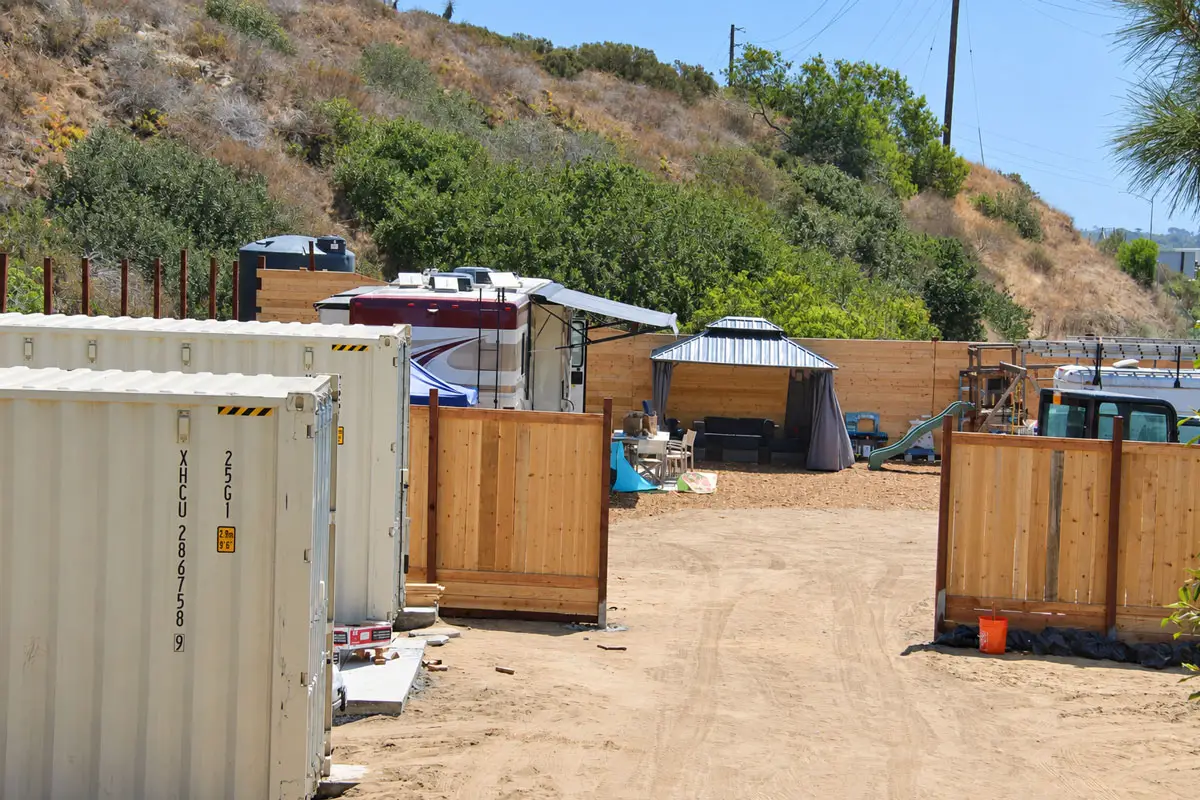 RVs, shipping containers and equipment occupy a lot near Interstate 5 at the southern end of Playa Riviera Drive in Encinitas. The city is considering legal action against property owner Matthew H. Wolff. Photo by Jordan P. Ingram