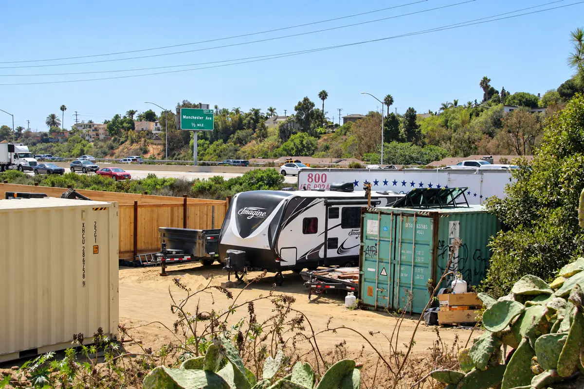A travel trailer sits beside shipping containers on an Encinitas property that has drawn code enforcement citations and concerns from neighbors. Photo by Jordan P. Ingram