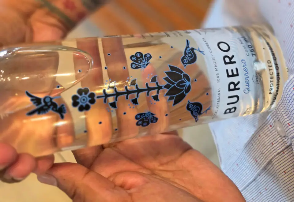 Saul Ocampo, a Marine veteran and founder of Ocampo Imports, holds a bottle of Burero Mezcal. Photo by Patrick Howell