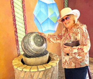 Docent Karyl Lammers provides perspective on the size of this crosscut section of giant sequoia that inhabits a lounge at Allegretto Vineyard Resort in Paso Robles. It is the starting point of her thrice-weekly art tours. The tree began growing before the Chinese began construction of the Great Wall in about 220 BCE. The tree fell in Sequoia National Park in 1952. Photo by E’Louise Ondash