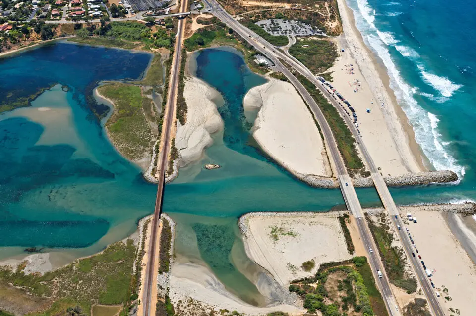 Rail tracks cross Batiquitos Lagoon, where crews will resume work this weekend as part of a project to add a second track and replace the aging rail bridge. Photo courtesy of SANDAG