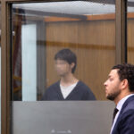 Jonathan William Badillo, left, appears behind glass with his attorney during an Oct. 7 hearing at the Vista Courthouse.