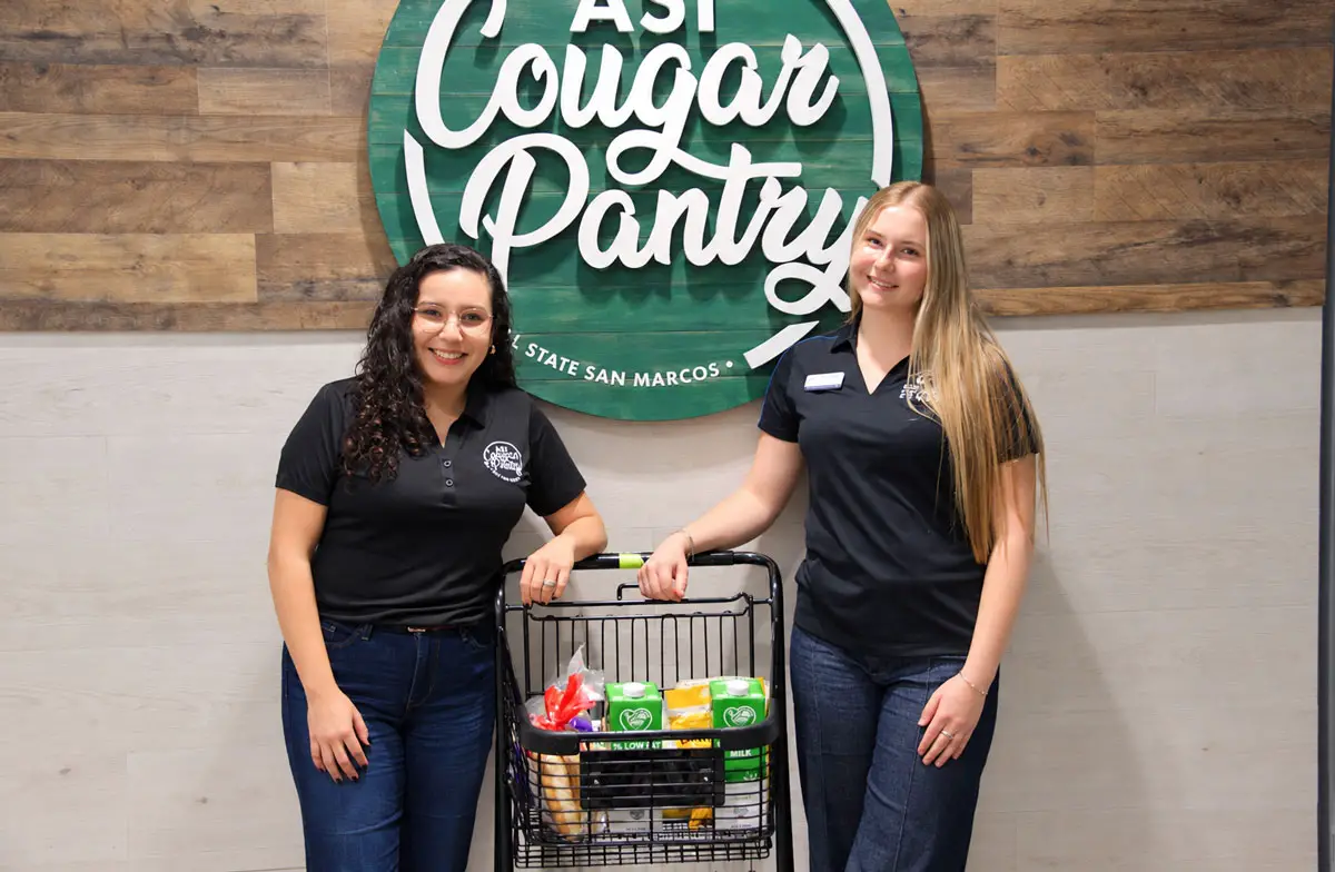 CSUSM pantry manager Alondra Lopez, left, and Associated Students Vice President Audrie Smith pose with a cart at the Cougar Pantry on campus. Photo by Jim Trageser