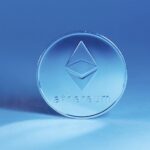Physical Ethereum token standing upright against a blue background.