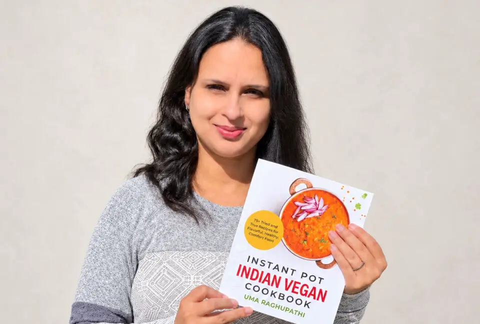 Uma Raghupathi, founder of Simple Sumptuous Cooking, holds her cookbook featuring plant-based Indian recipes. Courtesy photo