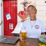 Jasmine Seelye serves up a Lola Says Hola Mexican Lager brewed by Carlsbad Pizza Port at Lola's 7Up Market & Deli. Photo by Jeff Spanier