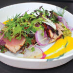 Blackened-Crusted Ahi Tuna at Mia's in Solana Beach, served with Mediterranean quinoa salad, Castelvetrano olive tapenade, ninja radishes and ginger-coconut emulsion. Photo by Rico Cassoni